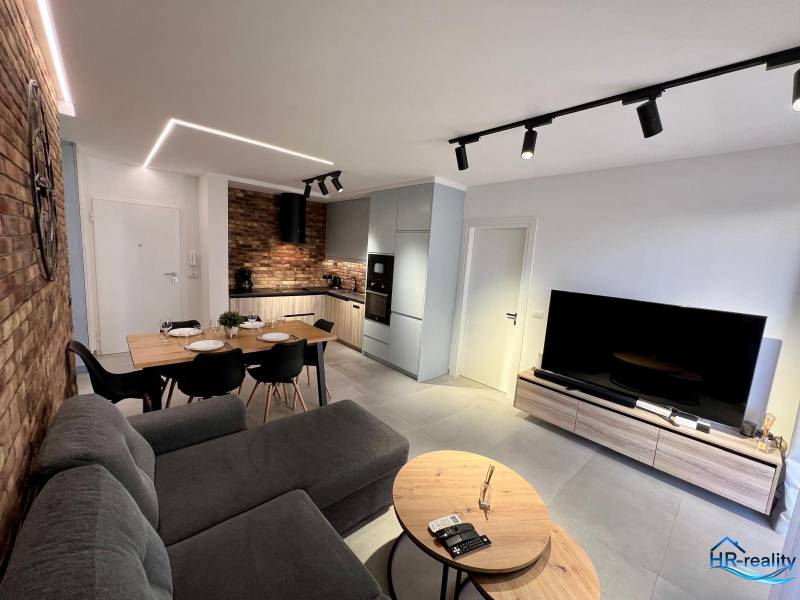 A nyaraló apartman nappalija konyhával, étkezőasztallal és kényelmes kanapéval van felszerelve.