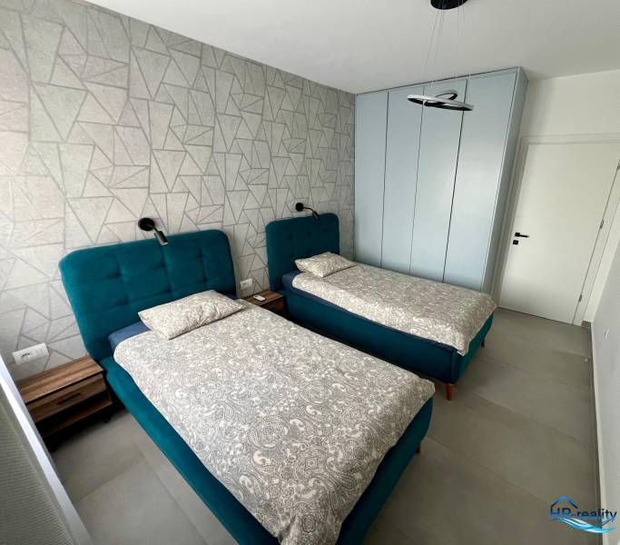 Kétszemélyes szoba kék ágyakkal és mintás fallal a Nyaraló apartmanban.
