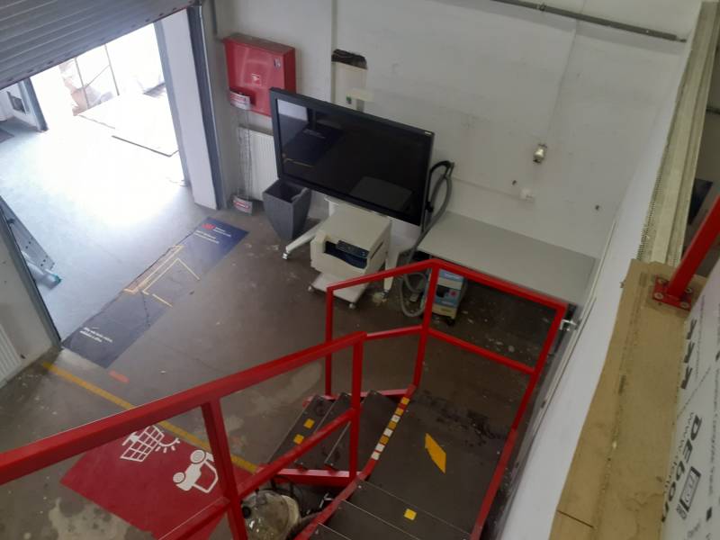 A raktárakban és csarnokokban van egy piros lépcsőház, egy képernyő és egy nyitott bejárati tér.