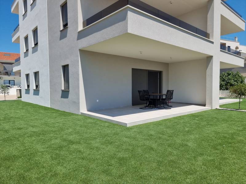 A Vodice-i 4 szobás lakás külseje modern terasszal és zöld gyepfelülettel.