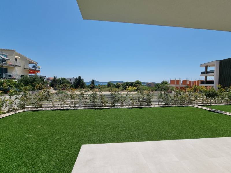 Kert a háromszobás lakásnál Vodice-ben, kilátással a környező épületekre és zöldterületre.