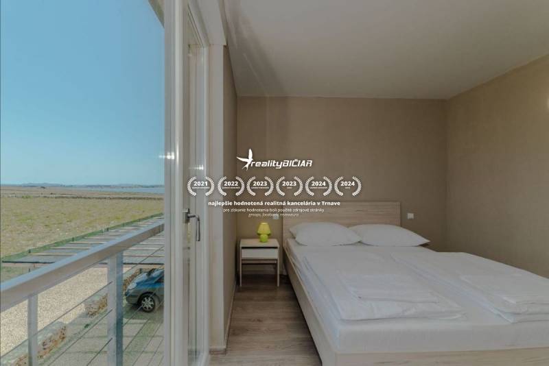 Hálószoba franciaággyal a nyaraló apartmanban, kilátással a nyílt vidékre.