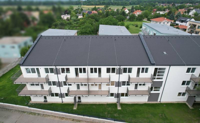 Lakóház a Muškátová utcában, Zálesie-ben, erkélyekkel és zöld környezettel.
