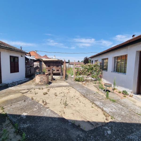 A családi ház udvara a Malackai Písniky-n, repedezett betonfelülettel és építményekkel.