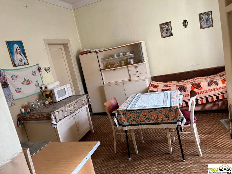 Családi ház konyhája étkezőasztallal, mikrohullámú sütővel és kanapéval.