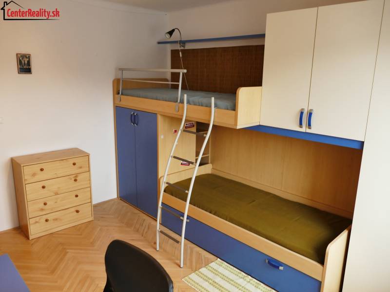 Gyerekszoba egy háromszobás lakásban emeletes ággyal és tárolóhellyel.
