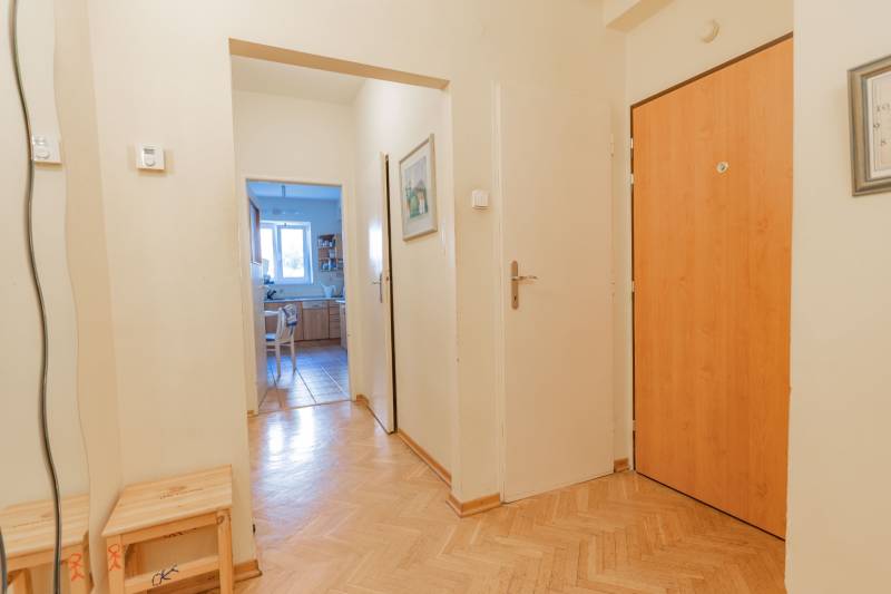 Folyosó a konyha bejáratával, fa dekoros padlóval, egy 4 szobás lakásban.
