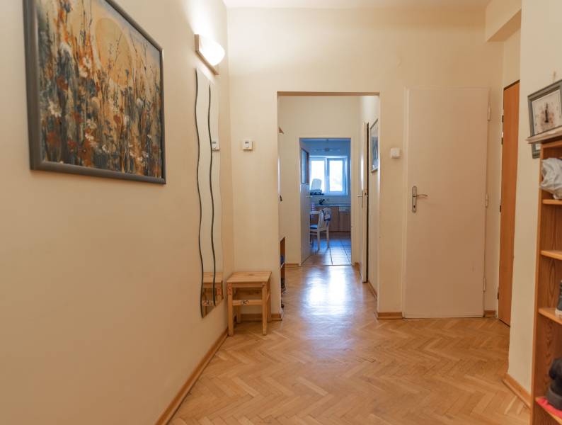 Folyosó egy 4 szobás lakásban laminált padlóval és egy képpel a falon.
