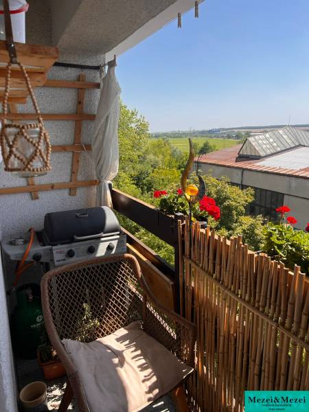 Erkély egy 3 szobás lakásban ülőgarnitúrával, grillel és kilátással a zöldre Pezinkben.