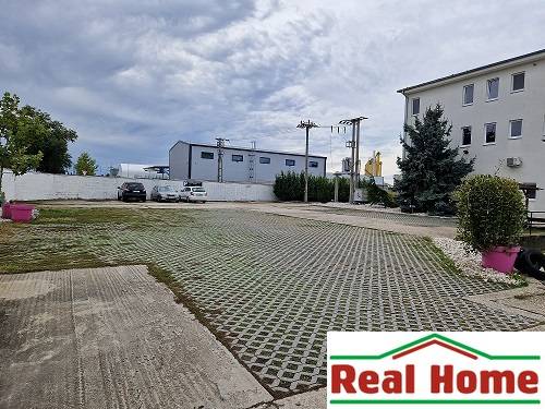 Šamorínska utca parkolója a raktárak és csarnokok mellett, ingatlanügynökség jelzésével.