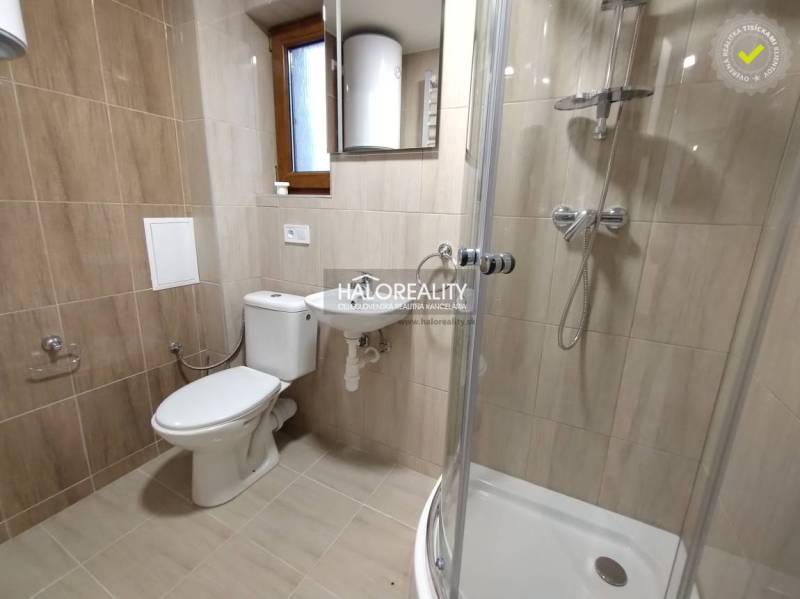 Fürdőszoba garzonlakásban WC-vel, mosdóval, zuhanyzóval és ablakkal.