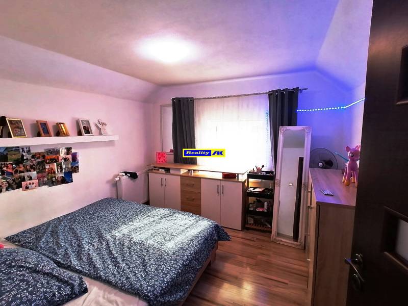 Hálószoba családi házban fa padlóval, dekorációkkal és tárolóhellyel.