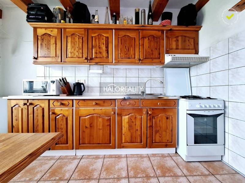 Rusztikus konyha szekrényekkel, sütővel és készülékekkel egy háromszobás lakásban.