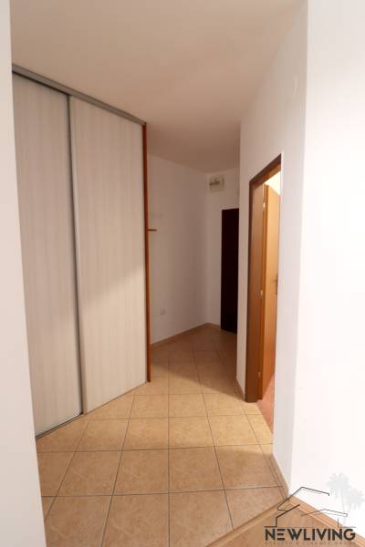 Folyosó beépített szekrénnyel és csempével egy 2 szobás lakásban.