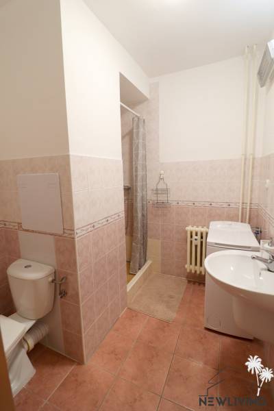 Fürdőszoba egy kétszobás lakásban WC-vel, zuhanyzóval és kerámia padlóval.