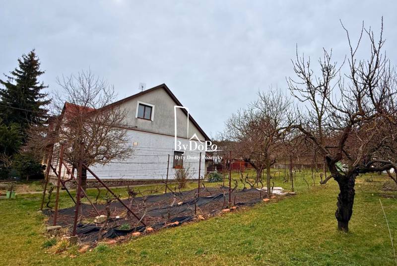 Családi ház a Nyitrai Vasutas utcában, kerttel és fákkal körülvéve.