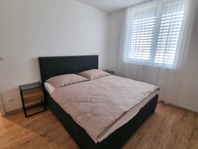 Hálószoba franciaággyal és éjjeliszekrényekkel egy háromszobás lakásban.