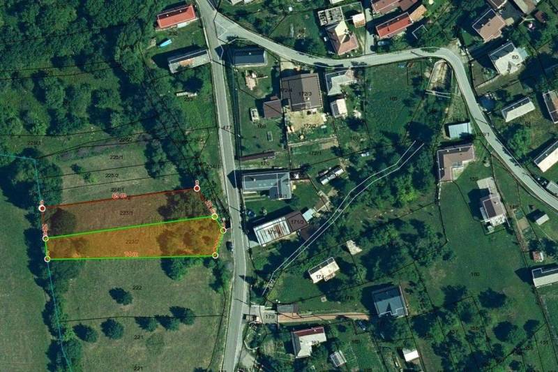 Légi felvétel Hanigovce környéki mezőgazdasági és erdőterületekről, parcellákkal és úthálózattal.