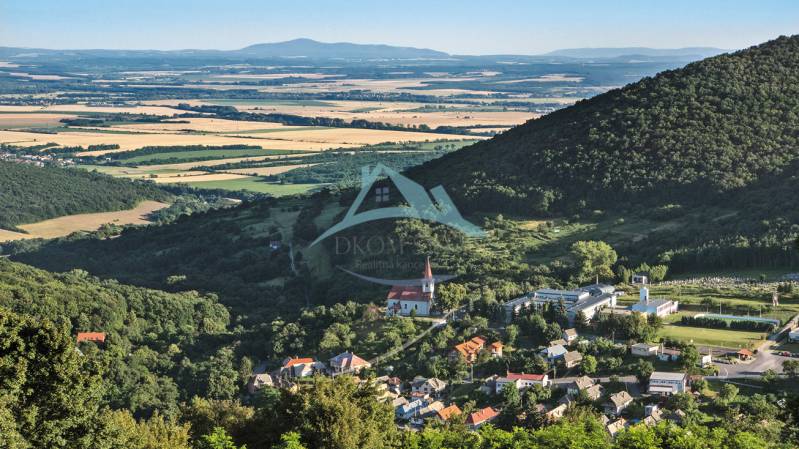 Panorámás kilátás egy falura a völgyben, erdőkkel és mezőkkel körülvéve. Lakhatásra alkalmas telkek.