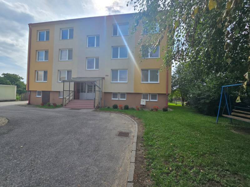 A kočovcei 4 szobás lakás külső része, háromemeletes lakóház zöldövezettel.