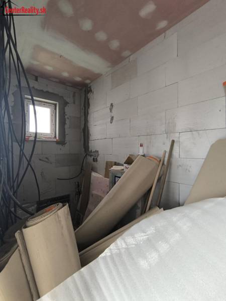 Stavebné materiály a elektroinštalácia v rozpracovanej miestnosti rodinného domu.
