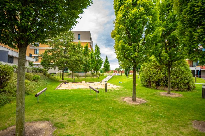 Játszótérrel rendelkező park a Bajkalská utcai lakóház mellett Pozsony-Ružinovban.