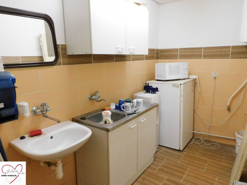 Konyha belső tér mosogatóval, mikrohullámú sütővel és hűtőszekrénnyel a raktárak és csarnokok területén.