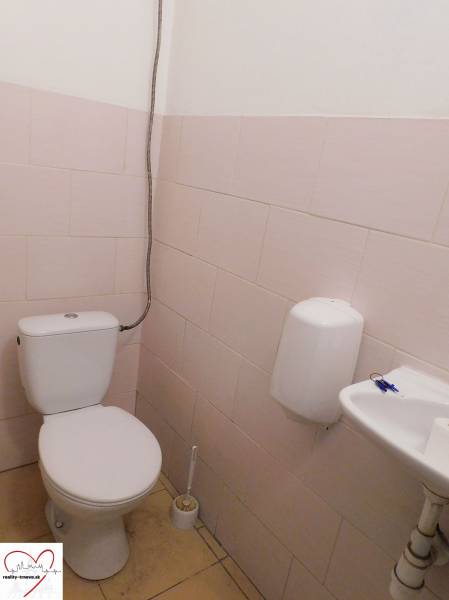 WC mosdóval és szappanadagolóval ipari épületben.