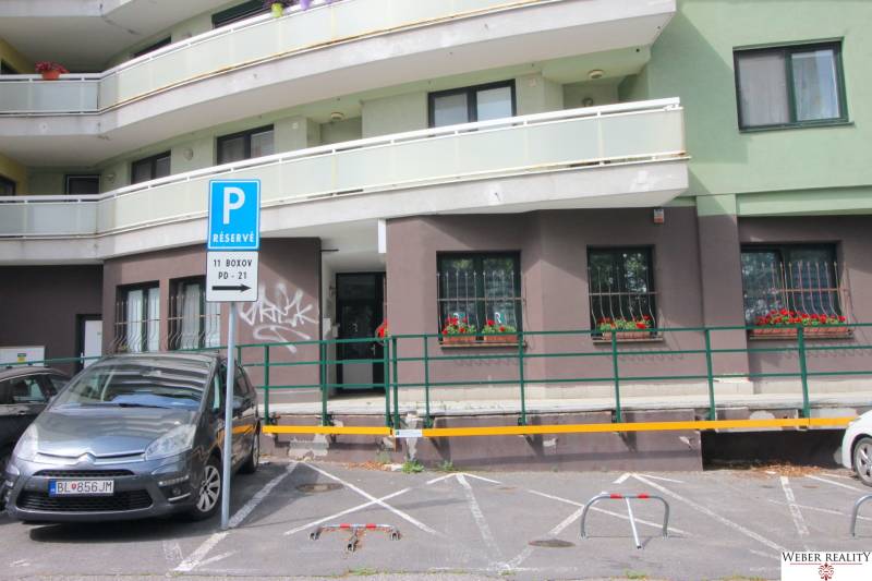 Parkoló a Žatevná utcai üzlethelyiségek előtt Pozsony-Dúbravkán.