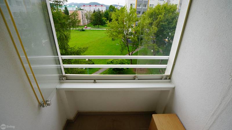 Erkély kilátással a zöldövezetre és épületekre Új-Dubnicán, ideális 2 szobás lakáshoz.