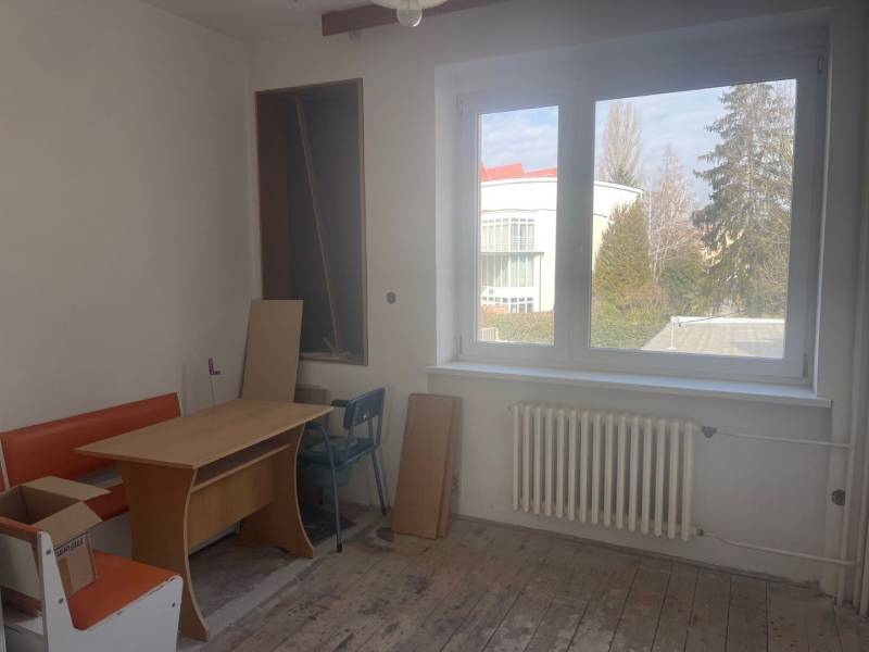 Családi ház belső tere ablakkal, asztallal és narancssárga paddal.