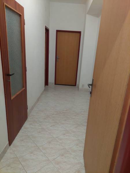 Folyosó egy családi házban csempével és faajtókkal.