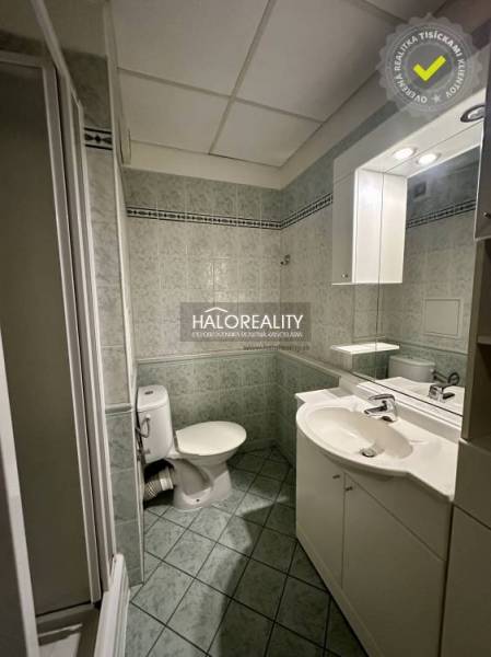 Fürdőszoba zuhanyzóval, mosdóval és WC-vel egy egyszobás lakásban.
