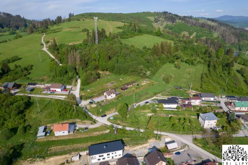 Légi felvétel Rakova lakóterületeiről, amelyeket zöld dombok és házak vesznek körül.