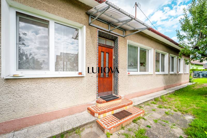 Pavla Koyša utcai családi ház Ladcóban fehér ablakokkal és ajtókkal.