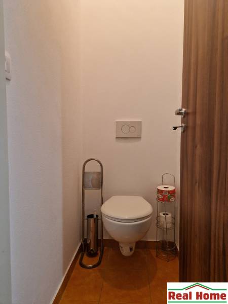 Fürdőszoba WC-vel és WC-papír tartókkal az egyszobás lakásban.