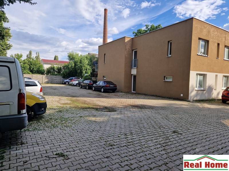 Tehelnej utcai parkoló Pezinkben autókkal és épülettel, hely egy egyszobás lakás számára.