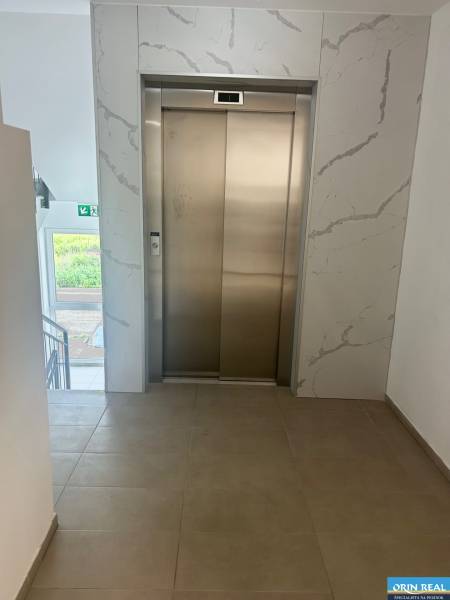 Lift a folyosón egy 3 szobás lakásban csempével és ablakkal.