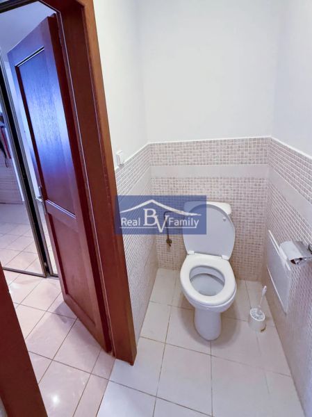 WC egy kétszobás lakásban egyszerű csempével és világos padlóburkolattal.