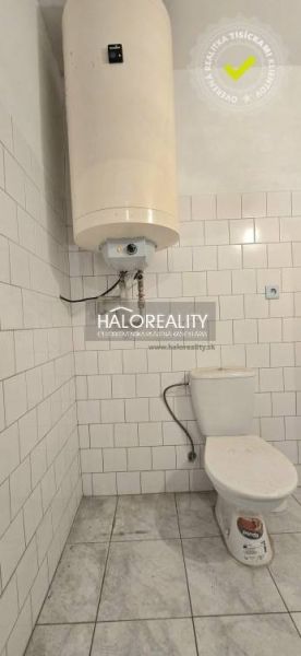 Fürdőszoba családi házban WC-vel és bojlerrel, fehér csempével burkolva.