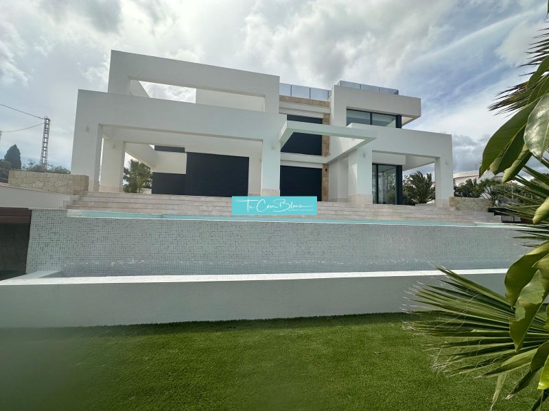 Modern építészetű villa medencével, zöldövezetben.