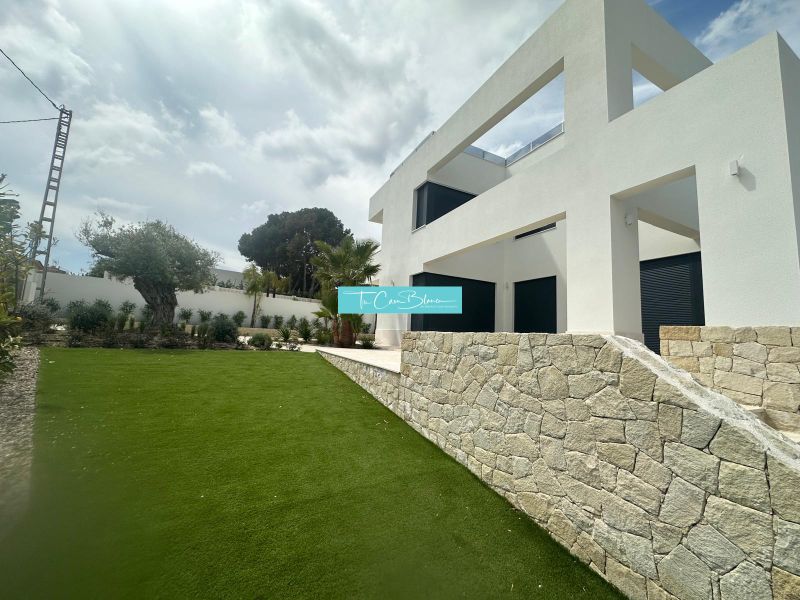 Villa Benissében kőfallal és gondozott kerttel, napos környezetben.