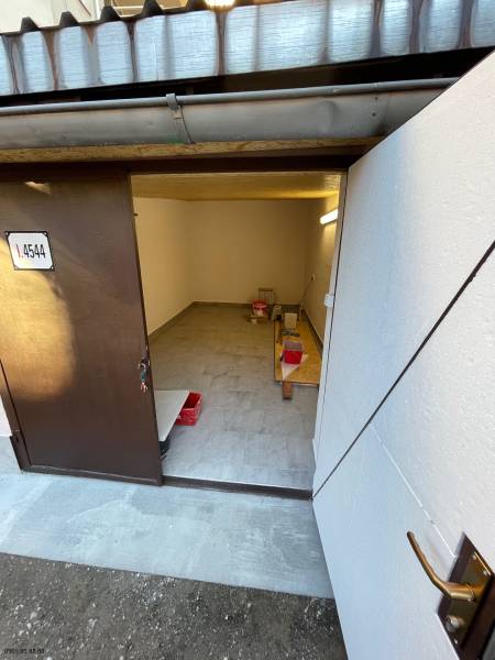 Garázs belső tér nyitott ajtókkal, fa dekorációjú padló, tárolóhely.