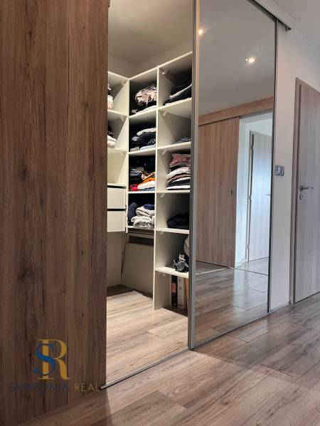 Beépített szekrény tolóajtókkal és fa dekorációjú padló családi házban.