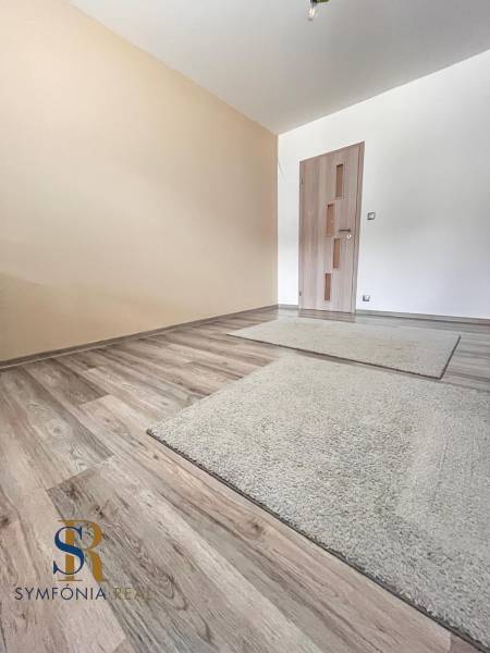 Családi ház helyisége fa dekorációjú padlóval és világos falakkal.