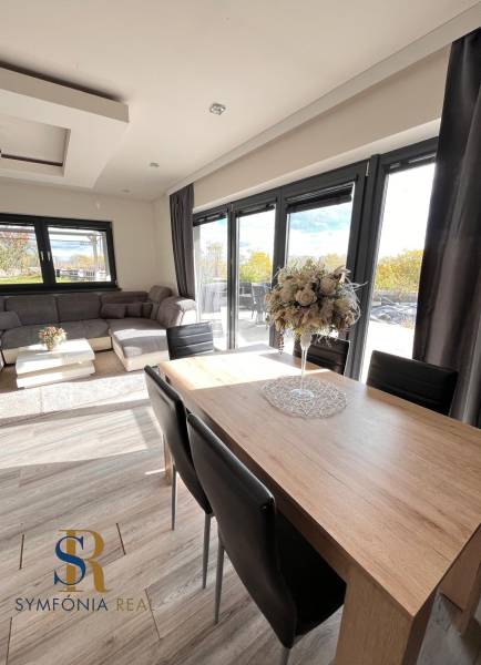 Családi ház nappalija fa dekorációjú padlóval és kényelmes ülőgarnitúrával.