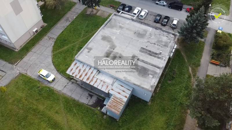 Kereskedelmi helyiségek épülete Rimaszombatban parkolóval és bekötőúttal.