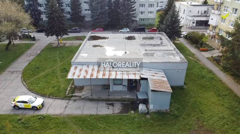 Kilátás a rimaszombati üzlethelyiségekre a szomszédos parkkal és beton tetővel.