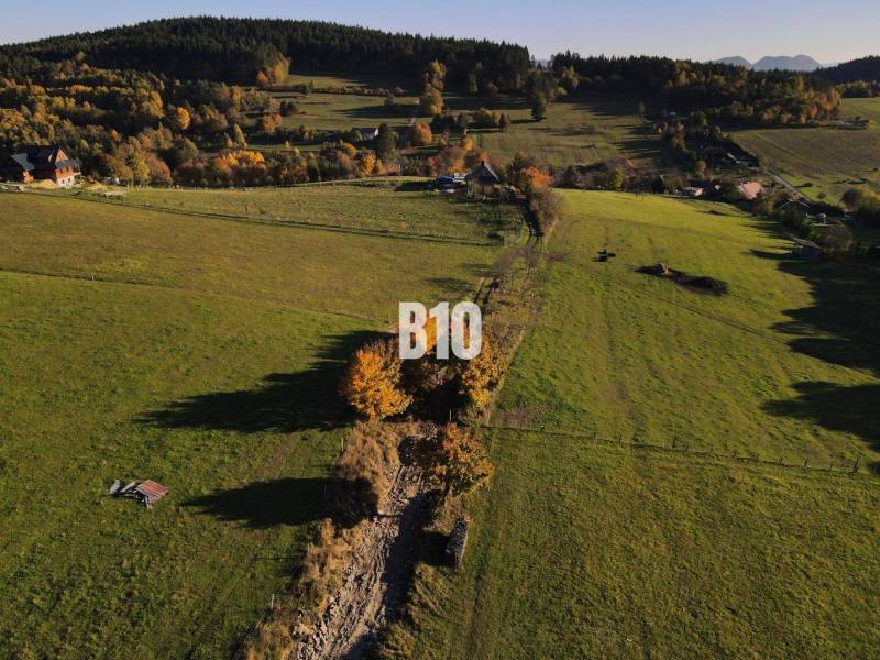 Zöldterületek és rétek a Pozemkoch-ban - lakóhely Petrovicében, fákkal és dombokkal körülvéve.