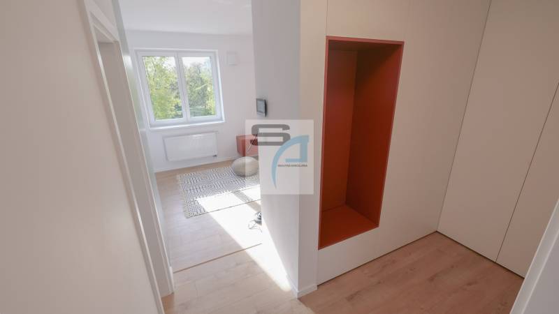 Folyosó egy kétszobás lakásban fa dekorációjú padlóval és kilátással a szobára.